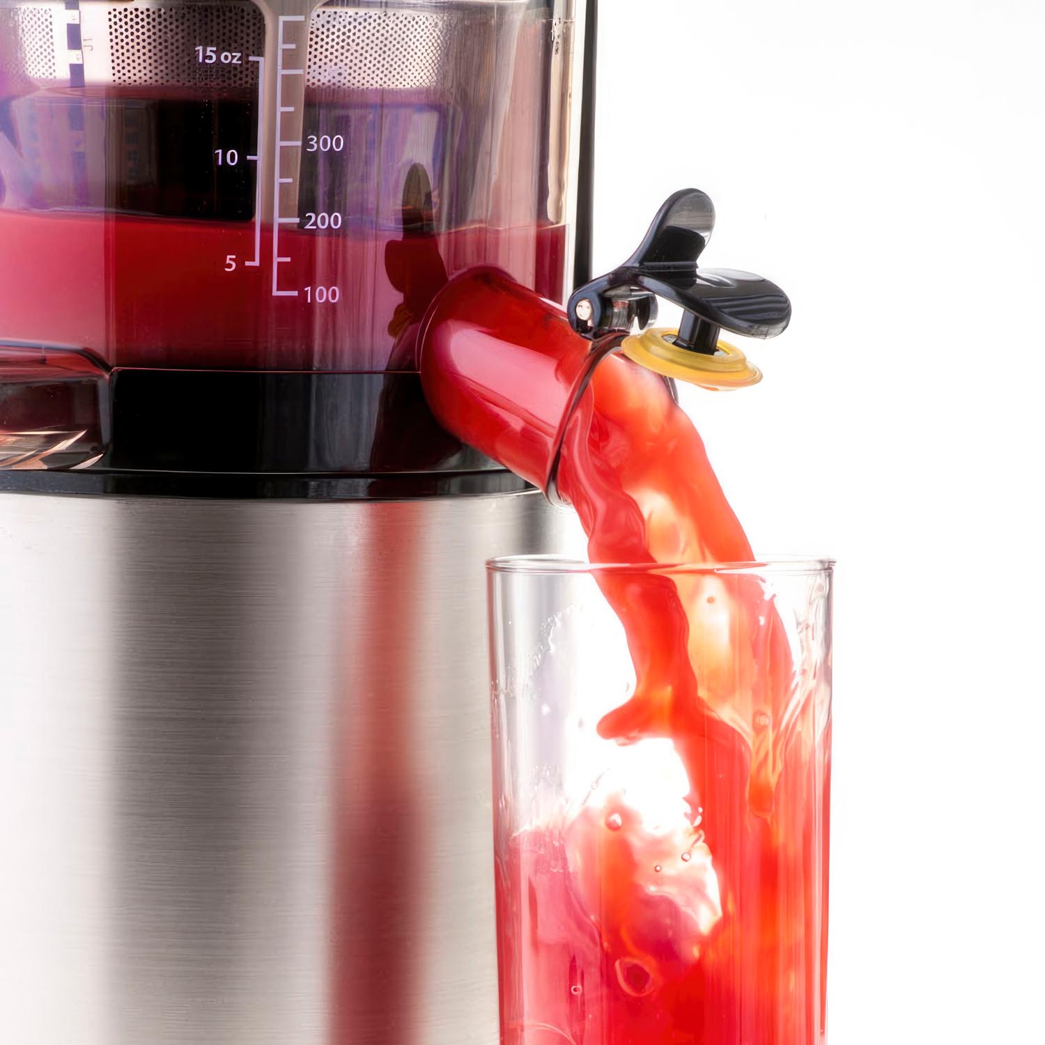 Commercial product photography of a juicer pouring juice into a glass